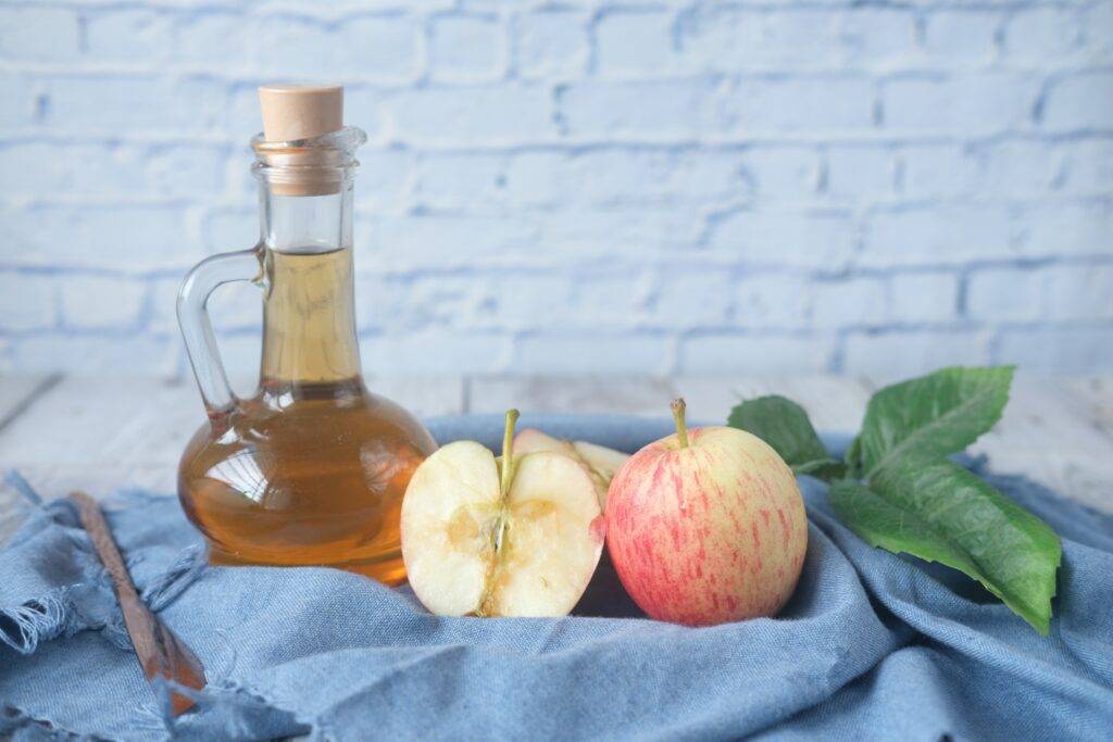 apples with bottle of apple cider vinegar