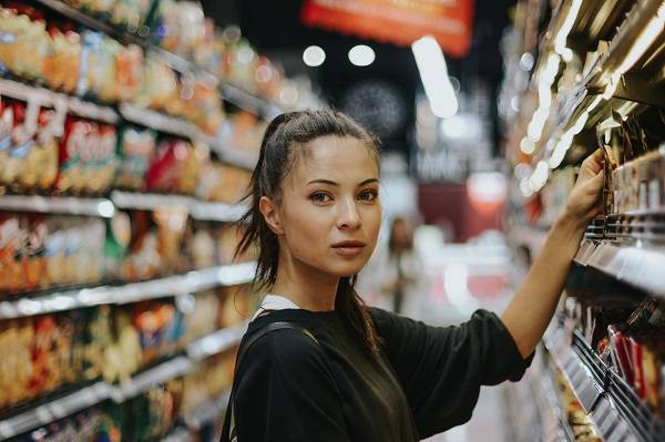woman choosing supplements at supermarket